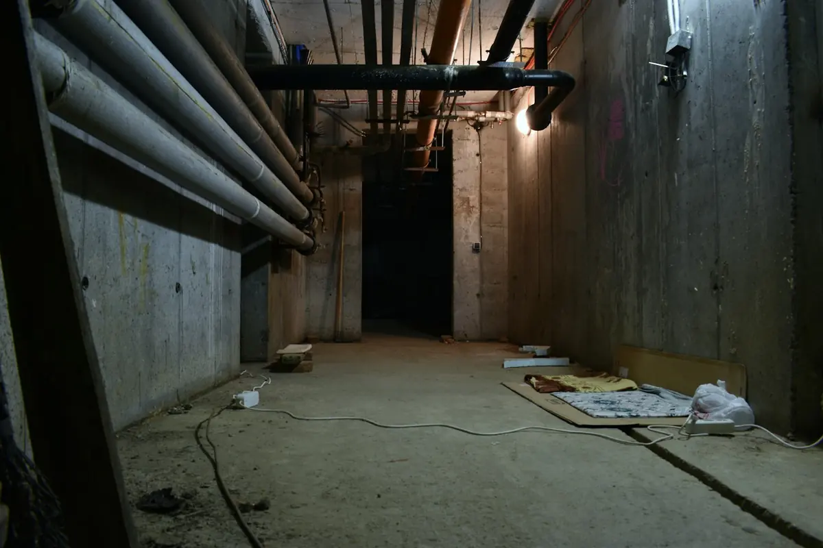 Below-ground basement space with exposed services before waterproofing